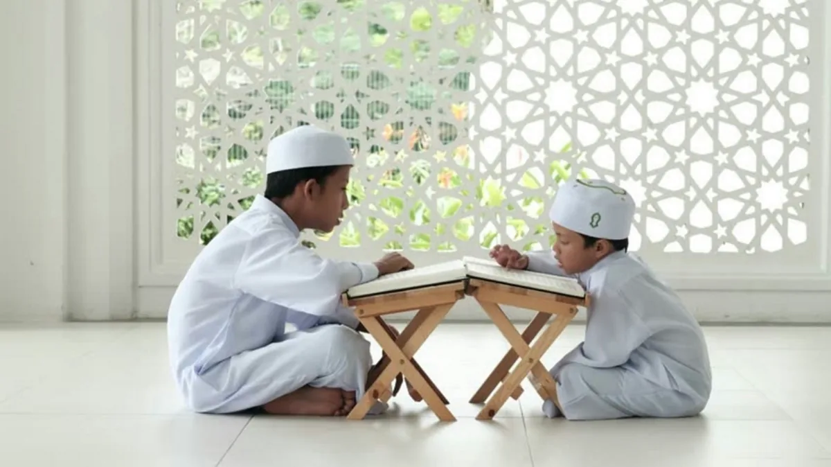 Two young students reading from Qurans on wooden stands